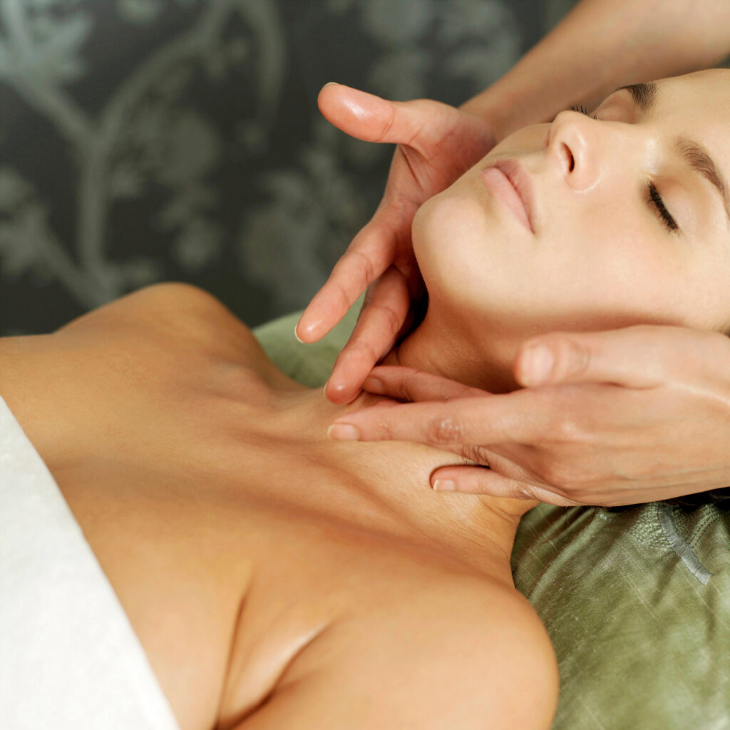 Masajista profesional aplicando técnicas de masaje descontracturante en el cuello y mandíbula para aliviar la tensión cervical en nuestro centro de masajes.
